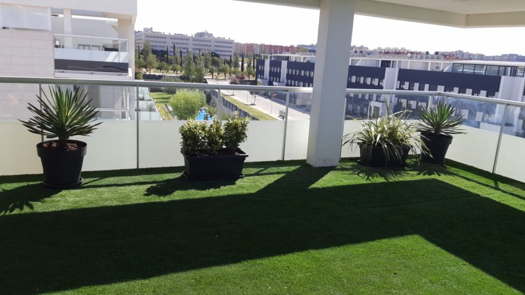 Terraza con césped artificial y macetas decorativas, diseño de espacios verdes en Zaragoza